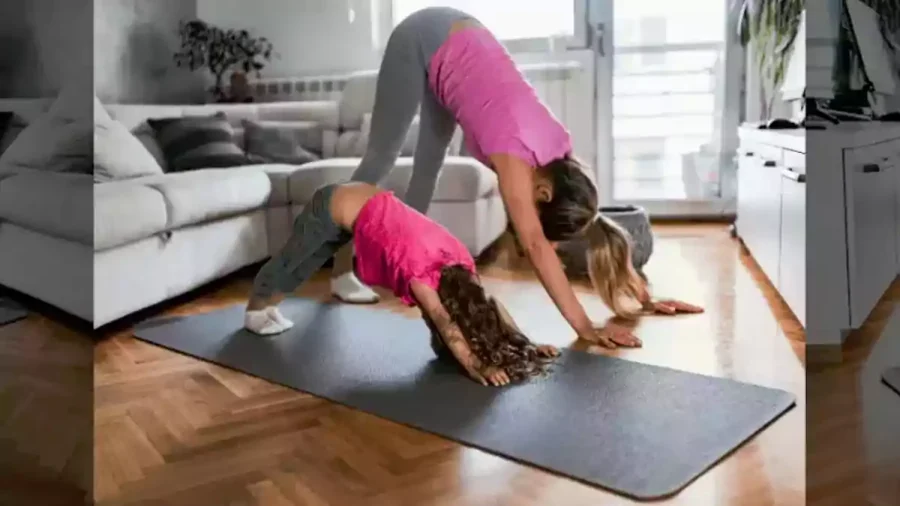 زن و دختر بچه در حال ورزش یوگا