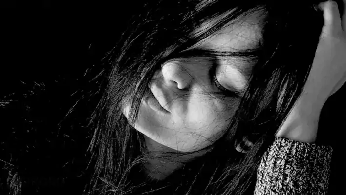زنی با لباس سیاه و موهای باز که خوابیده